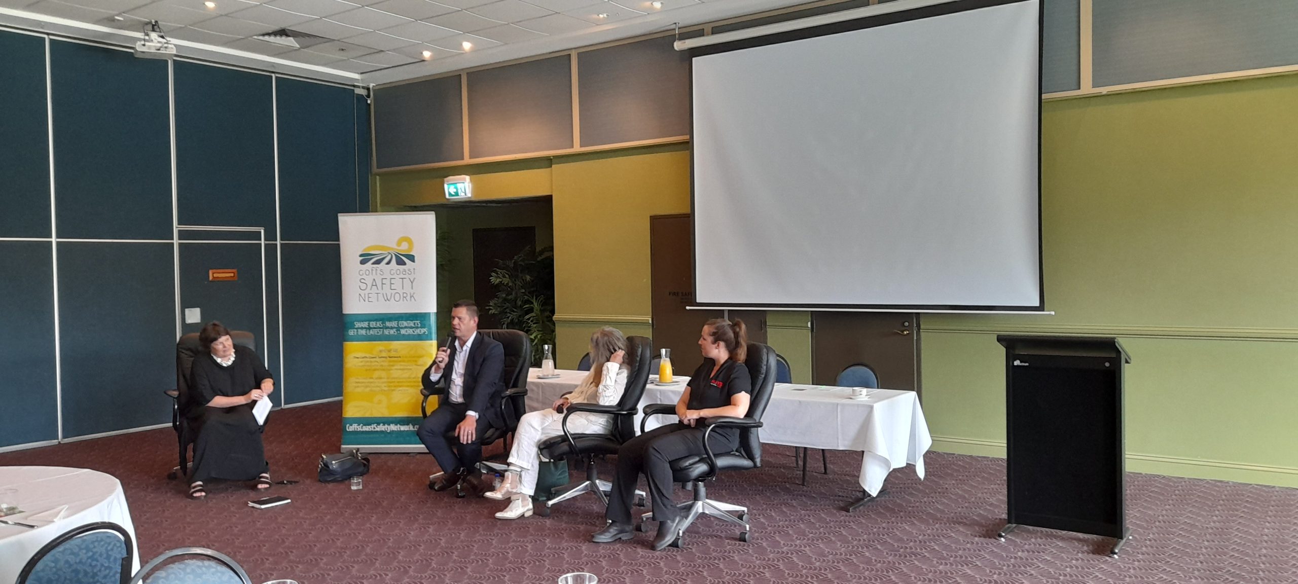 View from the right side of the room - The Q&A Panel for the 30 November 2022 event. From left to right are Olivia Jamieson (Organisational Culture Specialist), Simon Joice (Mid North Coast Local Health District), Rowena Bianchino (The Harbour Therapy Clinic), Larissa Davidson (Hoys Health).